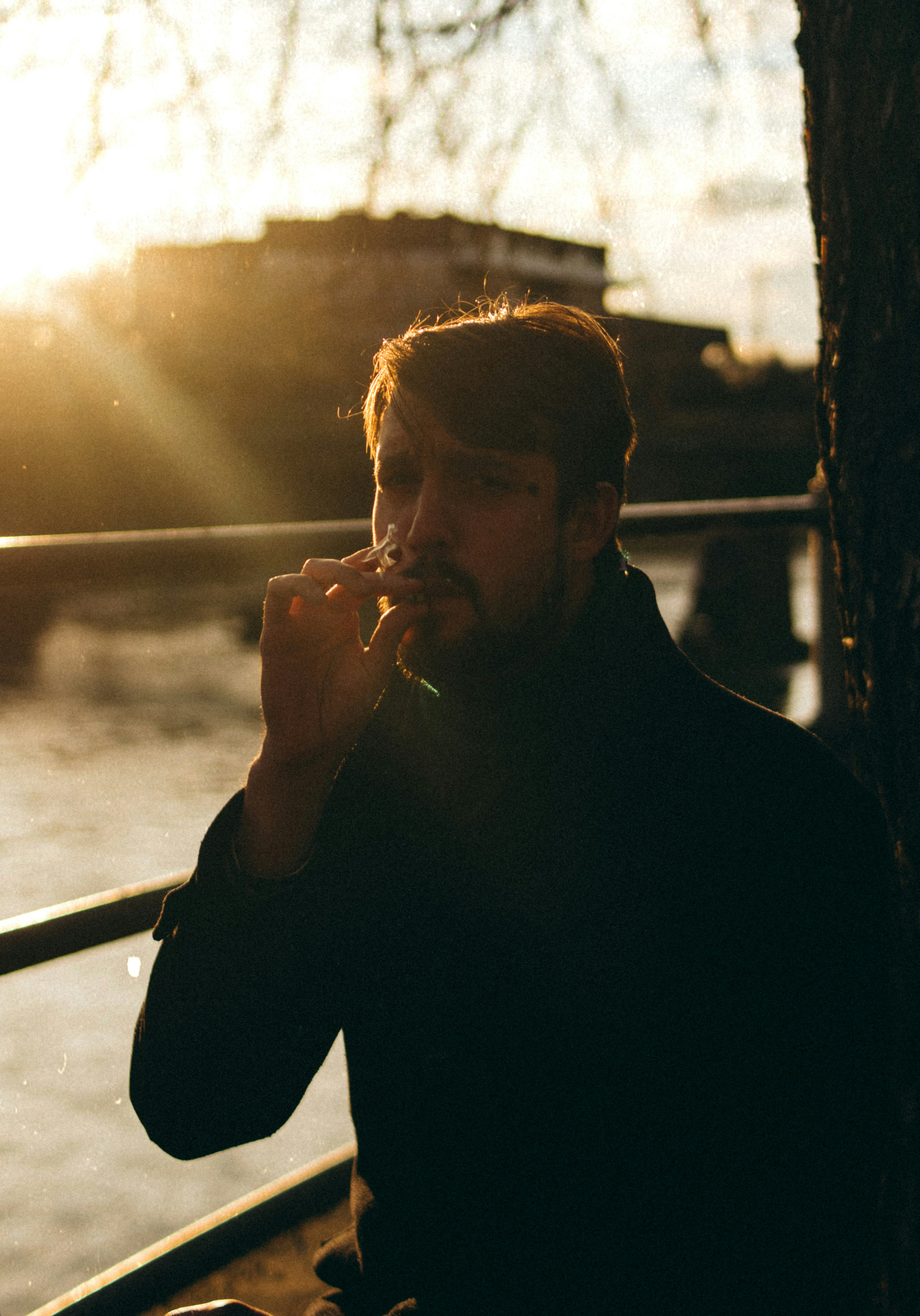 man in black long sleeve shirt smoking cigarette